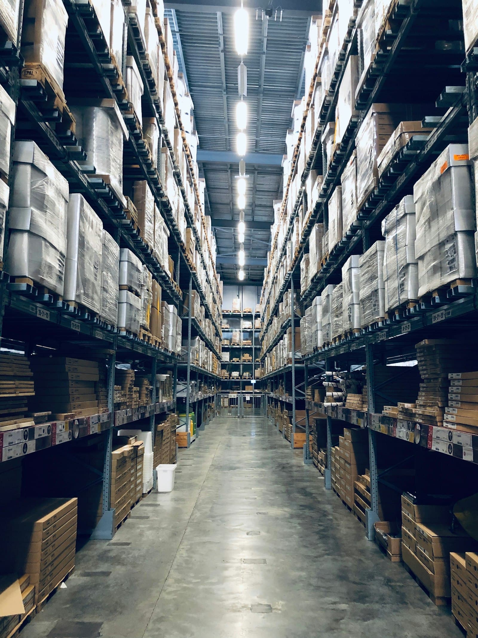 A high-bay warehouse aisle stacked with stock